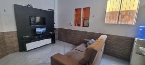 a living room with a couch and a flat screen tv at Casa temporada Lucena in Lucena