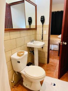 a bathroom with a toilet and a sink at Hotel León Inn in León