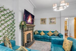 a living room with a blue couch and a fireplace at Boardman Lodge, City centre, Park view, Games - Ginger & Gold ltd in Norwich