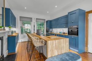 uma cozinha com armários azuis e uma ilha de madeira em Boardman Lodge, City centre, Park view, Games - Ginger & Gold ltd em Norwich