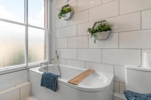 uma casa de banho branca com uma banheira e uma janela em Boardman Lodge, City centre, Park view, Games - Ginger & Gold ltd em Norwich