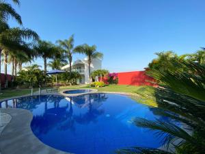 庫奧特拉莫雷洛斯的住宿－Hotel Cascada，一座棕榈树大型游泳池和一座房子