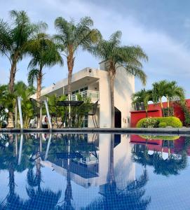 a house with palm trees and a swimming pool at Hotel Cascada in Cuautla Morelos