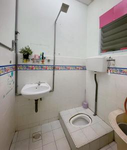 a bathroom with a toilet and a sink at HomestayMuslim Di Teluk Intan in Teluk Intan