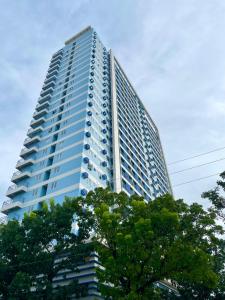 een hoog blauw gebouw met bomen ervoor bij The Loop Condotel in Cagayan de Oro