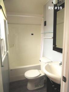 a bathroom with a white toilet and a sink at Boardwalk RV Rental Site #19 in Cavendish