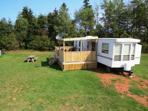a rv parked in a field with a picnic table at Boardwalk RV Rental Site #19 in Cavendish
