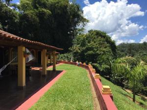 einen Garten mit einem Gebäude, Gras und Bäumen in der Unterkunft Sítio Vale do Sol in Pinhalzinho