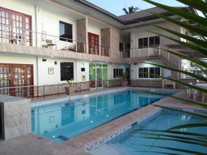 a swimming pool in front of a house at Ocean Breeze Resort in Toledo City