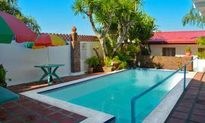 a swimming pool with a table and an umbrella at Isla Bonita Beach Resort in San Juan