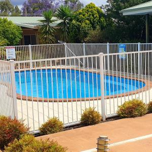 a white fence next to a swimming pool at Cobar Central Motor Inn in Cobar
