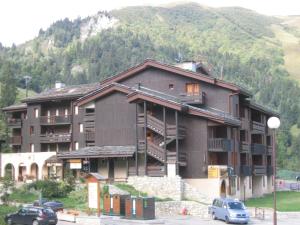 un gran edificio con coches estacionados frente a él en Appartement Valmorel, 1 pièce, 4 personnes - FR-1-356-280, en Valmorel