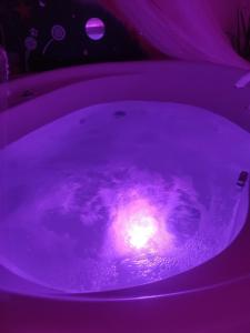 uma banheira roxa com uma vela em Pension Relax-Hvězdička em Litoměřice