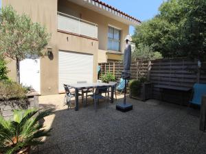 um pátio com uma mesa e cadeiras e um edifício em Appartement Collioure, 2 pièces, 4 personnes - FR-1-309-233 em Collioure