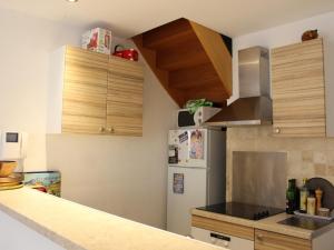 uma cozinha com um frigorífico branco e armários de madeira em Appartement Collioure, 2 pièces, 4 personnes - FR-1-309-233 em Collioure