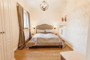 een slaapkamer met een bed, een raam en een kroonluchter bij Waldchalet Am Steinberg FEWO in Wernigerode