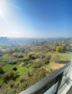 uma vista para um campo relvado a partir de uma varanda em Üniversite kapısında köy manzaralı daire 