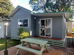 a tiny house with a picnic table in front of it at Jacaranda Holiday Park in North Haven