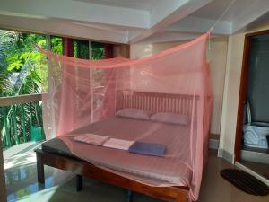 a bed in a room with a mosquito net at Hin Wong Apartments Dive & Snorkel Resort in Koh Tao
