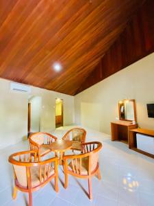 una stanza con tavolo, due sedie e televisore di Landcons Hotel & Resort a Pantai Cenang