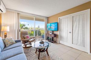a living room with a blue couch and a glass table at Maui Banyan H311 1BD 2BA 3 min walk to the beach in the Heart of South Kihei! in Wailea