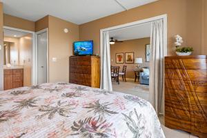 a bedroom with a bed and a living room at Maui Banyan H311 1BD 2BA 3 min walk to the beach in the Heart of South Kihei! in Wailea