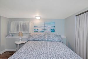 a bedroom with a bed with a blue bedspread at Quaint 1 bedroom lower suite in Victoria, BC in Victoria