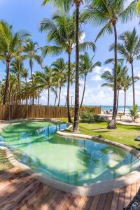 una piscina con palmeras en el fondo en Villa Kandui Boutique Hotel e Beach Lounge en Barra Grande