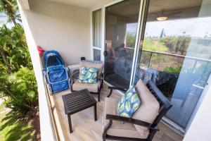 a screened in porch with two chairs and a couch at Maui Banyan H311 1BD 2BA 3 min walk to the beach in the Heart of South Kihei! in Wailea