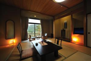 花卷的住宿－Watari Onsen Bettei-Kaede，客厅设有桌子和大窗户