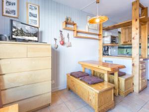 a kitchen with wooden cabinets and a table with a bench at Studio Val-d'Isère, 1 pièce, 4 personnes - FR-1-694-81 in Val-d'Isère