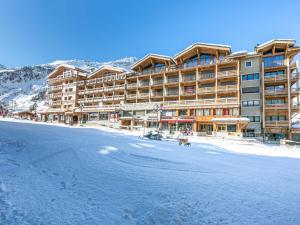 a large building in the snow with a dog in front at Appartement Val-d'Isère, 5 pièces, 8 personnes - FR-1-694-89 in Val-d'Isère