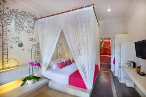 a bedroom with a white bed with pink pillows at PinkCoco Uluwatu - for Cool Adults Only in Uluwatu