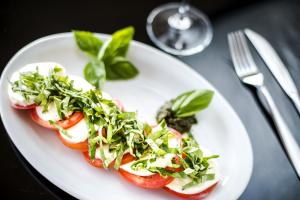 un plato de comida con tomates y verduras. en Beachfront Hotel Tramonto en Jacó