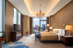 a bedroom with a large bed and a large window at Wanda Vista Dongguan in Dongguan