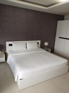 a bedroom with a large white bed with a white bedspread at Grand Residence Jomtien in Jomtien Beach