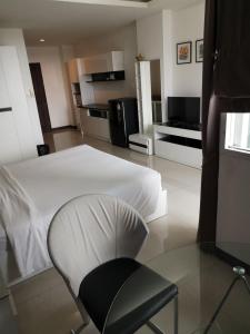 a bedroom with a white bed and a chair at Grand Residence Jomtien in Jomtien Beach