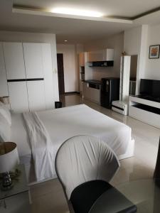 a bedroom with a white bed and a chair at Grand Residence Jomtien in Jomtien Beach