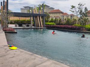 - deux enfants dans la piscine d'un complexe dans l'établissement KL EAST RIDGE RARA SUITE HOMESTAY, à Kuala Lumpur