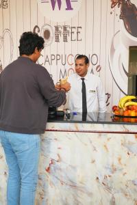 a man is talking to a man standing at a counter at Wahaj Al Mesak Units in Dammam