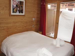 une chambre avec un lit blanc avec une fenêtre dans l'établissement Appartement haut de gamme au centre, animaux admis, WiFi - FR-1-694-107, à Val dʼIsère