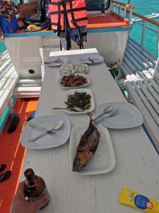 a table with plates of food on a boat at Tribe Banua 