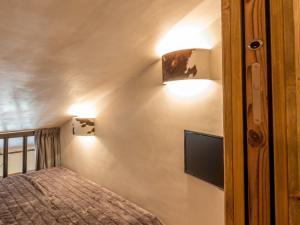 a bedroom with a bed and two lights on the wall at Appartement luxe avec wifi et parking sur les pistes au cœur de Val-d'Isère - FR-1-694-133 in Val dʼIsère