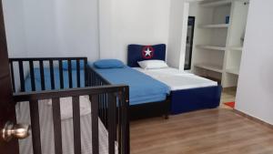 Un pequeño dormitorio con una cama azul con una capa. en Cabaña la isla, en Coveñas
