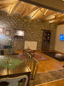 a living room with a table and a stone wall at Meraki in Kalabaka
