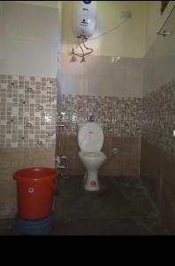 een badkamer met een toilet en een emmer bij Dog n Hill in Kasol