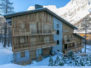 a log cabin in the snow with a balcony at Appartement confortable avec garage et wifi dans secteur calme à Val-d'Isère - FR-1-694-154 in Val dʼIsère