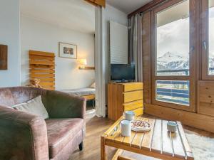 a living room with a couch and a tv and a table at Studio Val-d'Isère, 1 pièce, 4 personnes - FR-1-694-175 in Val-d'Isère