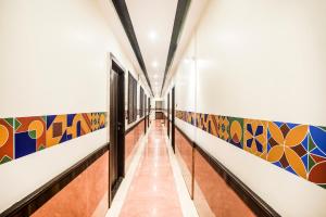 un pasillo con murales coloridos en las paredes en FabHotel Amour - Nr Mumbai International Airport, en Bombay
