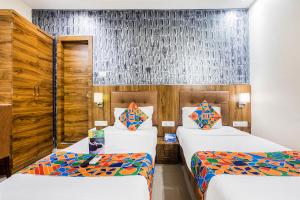 Habitación de hotel con 2 camas y pared en FabHotel Amour - Nr Mumbai International Airport, en Bombay 16 fotos más